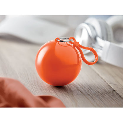 Bola naranja de plástico con poncho impermeable dentro