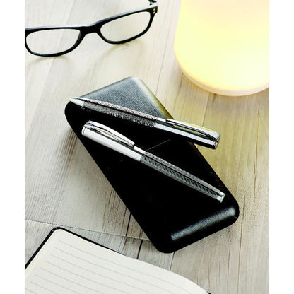 Set de escritura en caja negra con bolígrafo y roller metálicos sobre mesa de oficina