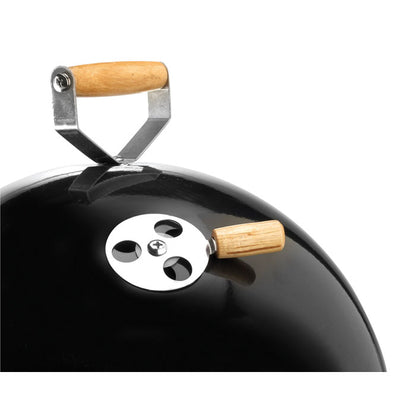 Detalle de chimenea de barbacoa negra con asa de madera