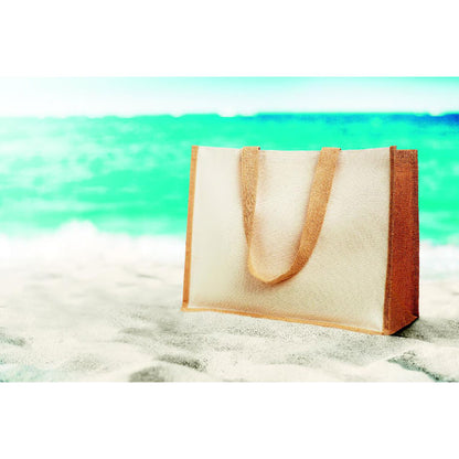 Bolsa de yute y canvas en toalla con el mar de fondo