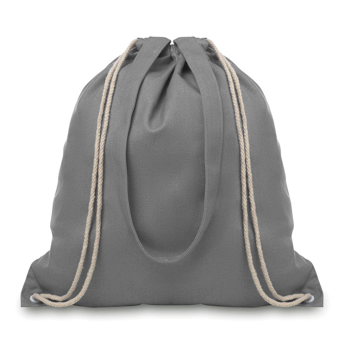 Mochila en canvas color gris con asas largas y cordón de cierre, vista posterior.