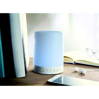 Altavoz con luz azul sobre mesa de escritorio
