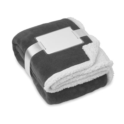 manta reversible de tejido grueso polar bicolor: gris y blanco.  Envuelta en cinta  y con tarjeta blanca