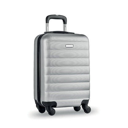 Trolley rígido de viaje color gris con 4 ruedas y con pequeña chapa metálica para personalizar