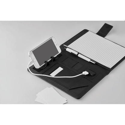 Vista superior de porta folios abierto con libreta y accesorios