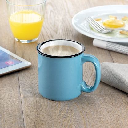 Café con leche en taza de cerámica azul en mesa de desayuno