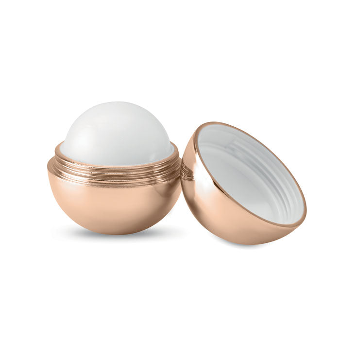 Bálsamo labial redondo UV con acabado metálico en color champán, abierto mostrando el producto blanco.