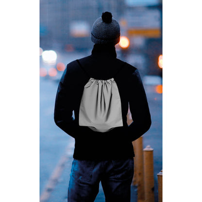 Chico vestido de negro y  con mochila gris reflectante a la espalda