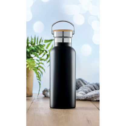 Botella de acero negro con tapa de madera sobre mesa de madera