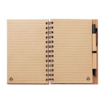 Vista superios de libreta de bambú con espiral y bolígrafo
