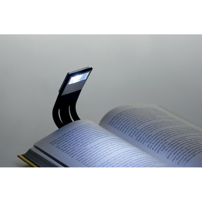 Lámpara de lectura encendida sobre libro