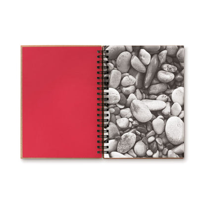 Libreta con espiral abierta. El interior de la portada es de color rojo y la primera hoja tiene una foto de piedras