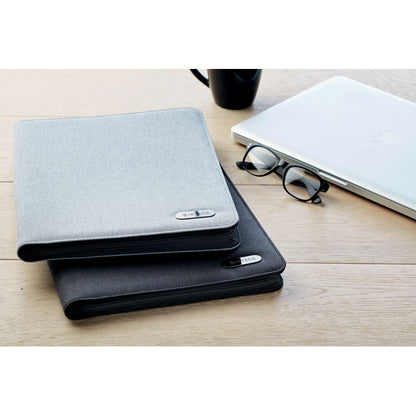 Carpeta gris y negra con cierre cremallera sobre mesa de oficina personalizadas con logotipo