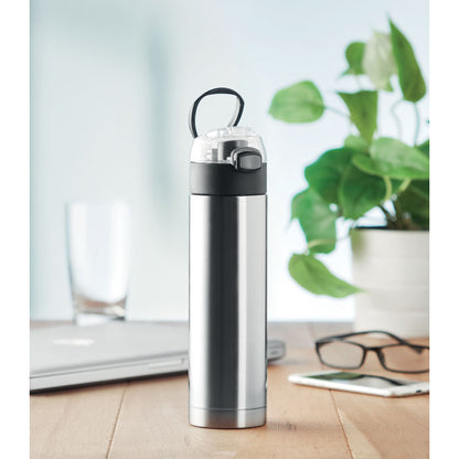 Mesa botella de acero, planta, gafas y portátil