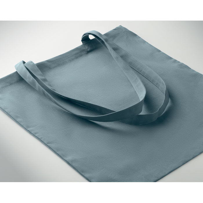 Bolsa de algodón color azul grisáceo con asas largas y superficie lisa, vista superior.