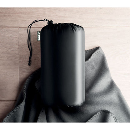 Funda de manta polar gris sobre madera
