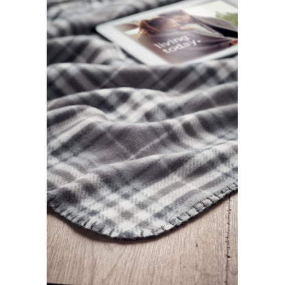 destalle de borde de manta de cuadros gris sobre madera