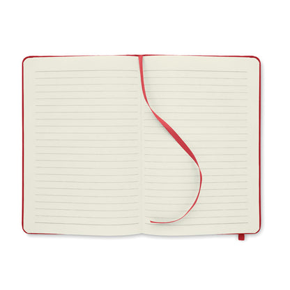 Libreta tamaño DinA5 abierta con hojas rayadas de papel reciclado color crema y con cinta marcapáginas de tela roja 