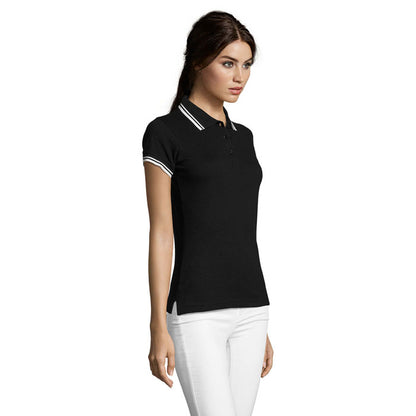 Vista lateral de polo negro con ribetes blancos en modelo femenina