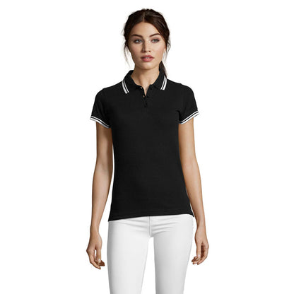 Modelo femenina con polo negro con cuello ribeteado, plano frontal