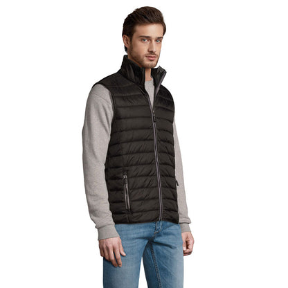 Chaleco acolchado negro en vista lateral con modelo masculino.