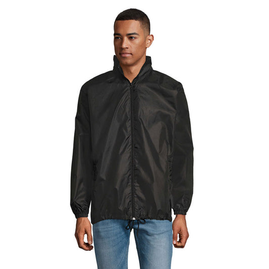 Hombre usando la chaqueta SHIFT - SHIFT CORTAVIENTO UNIX en color negro, con cremallera y capucha ajustable.