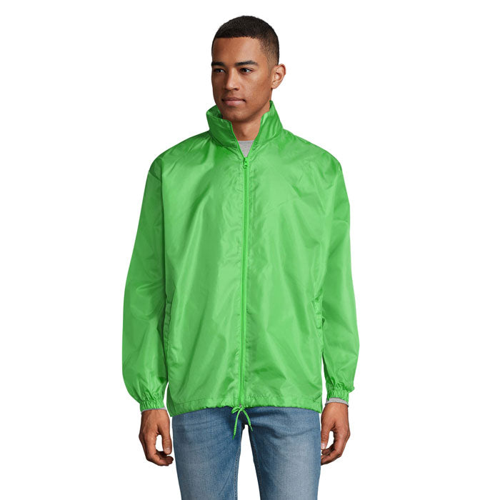 Modelo usando una chaqueta cortaviento verde SHIFT - SHIFT CORTAVIENTO UNIX con cierre y capucha.