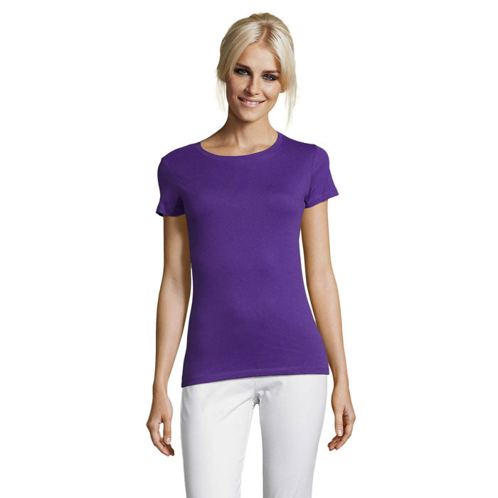 Modelo usando camiseta morada de cuello redondo, confeccionada en 100% algodón, con corte ceñido y mangas cortas.