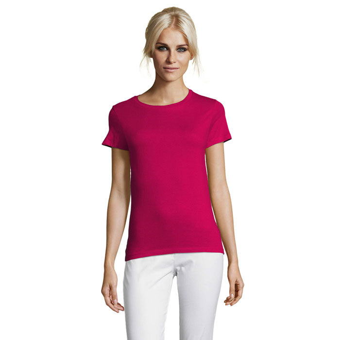 Modelo femenino luciendo camiseta fucsia de cuello redondo, confeccionada en algodón, con corte ceñido y mangas cortas.
