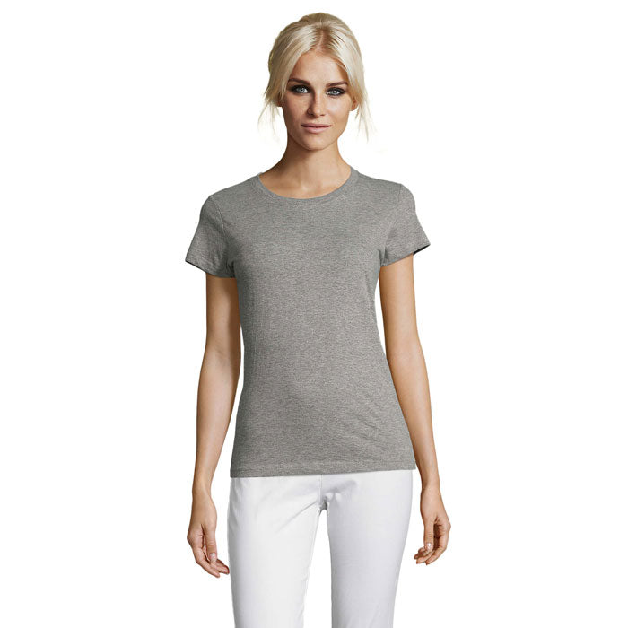 Mujer con camiseta gris de manga corta y corte ceñido, fabricada en algodón. Estilo sencillo y cómodo para el uso diario.