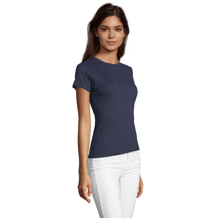 Vista lateral de una camiseta de mujer de color azul marino, entallada, con mangas cortas y cuello redondo, combinada con pantalones blancos.