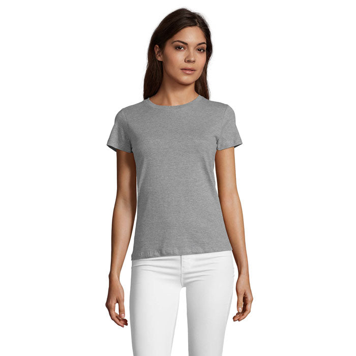 Vista frontal de mujer usando camiseta gris de cuello redondo, 100% algodón, corte ajustado, combinada con pantalones blancos.