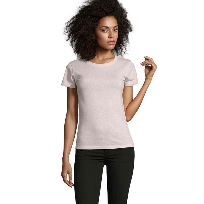 Modelo en camiseta de mujer entallada color rosa claro, 100% algodón, con corte clásico y mangas cortas.