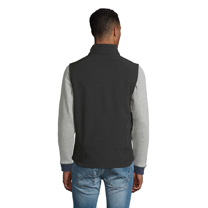 Vista posterior de chaleco softshell en color gris oscuro, combinando con mangas grises, ideal para hombre.