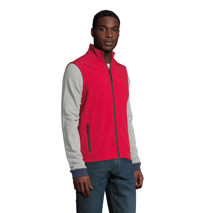 Chaleco softshell rojo con mangas grises, vista lateral, ideal para actividades al aire libre, combina comodidad y estilo.