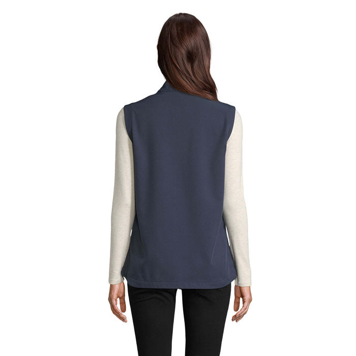 Vista posterior de chaleco softshell azul marino para mujer, con diseño sin mangas y ajuste moderno.