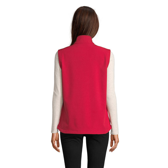 Vista posterior de chaleco softshell femenino en color rojo, con detalles en sutil textura.