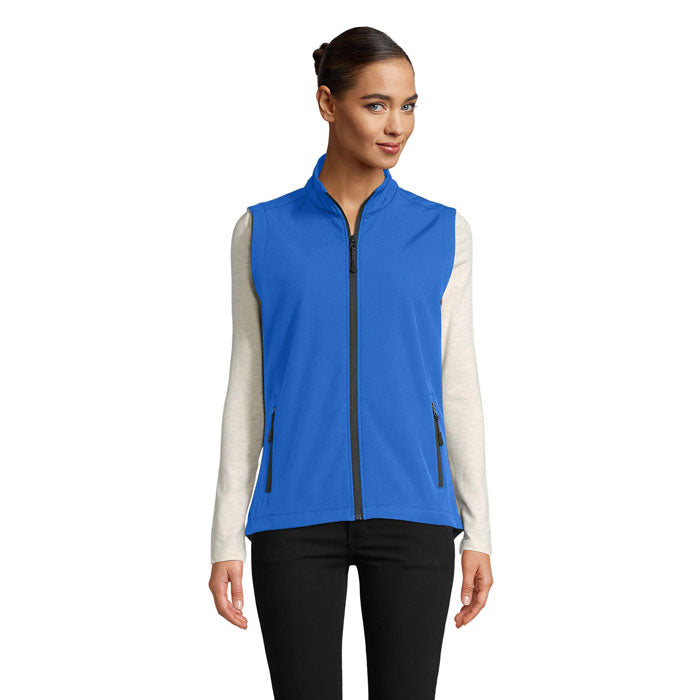 Vista frontal de chaleco softshell azul para mujer, con cremallera y bolsillos con cierre.