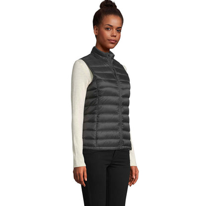Vista lateral de chaleco acolchado negro en modelo femenina