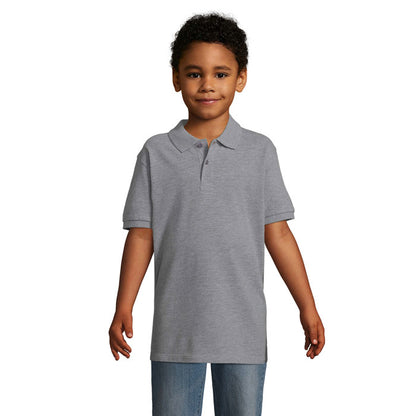 Polo infantil negro de manga corta visto de frente con modelo niña sonriendo.