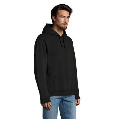 Modelo hombre con sudadera negra de perfil, corte recto y capucha caída.