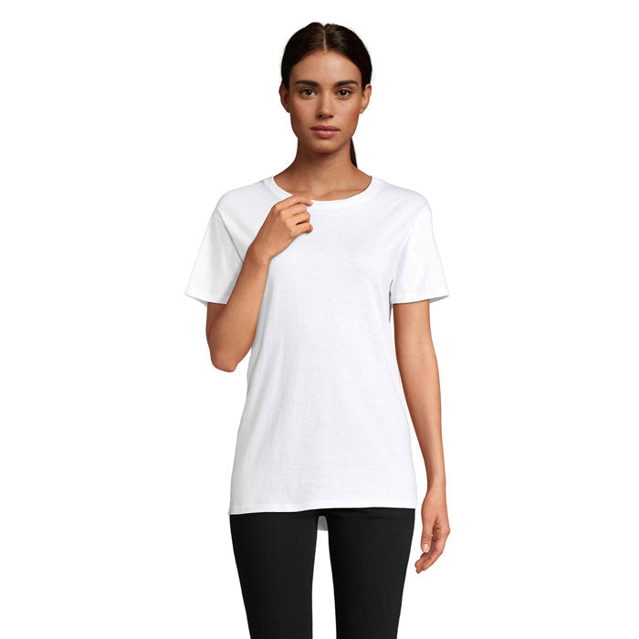 Modelo femenino vistiendo camiseta blanca de algodón orgánico con cuello redondo y corte ajustado, mostrando un look casual.