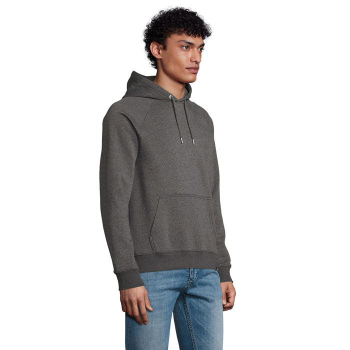 Modelo posando con sudadera gris de capucha STELLAR, fabricada en algodón orgánico y poliéster reciclado.
