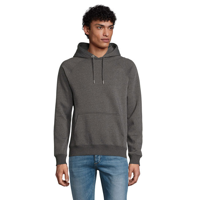 Modelo con sudadera con capucha en color gris, confeccionada en 80% algodón orgánico, 20% poliéster reciclado, detalle de bolsillo frontal.