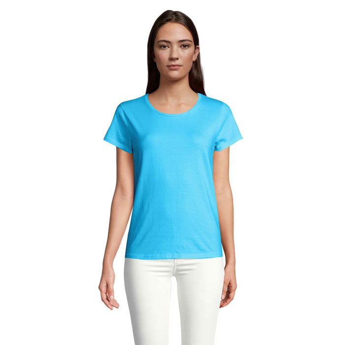 Mujer vistiendo camiseta ajustada de color aqua, de algodón orgánico, con cuello redondo y manga corta, frente a la cámara.