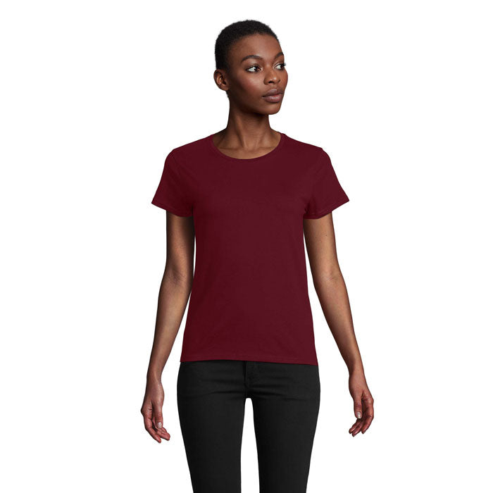 Camiseta ajustada de color burdeos, 100% algodón orgánico, mujer de pie mostrando su estilo.