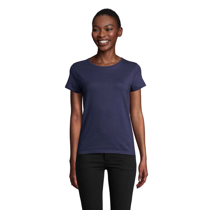 Modelo sonriente que viste camiseta de mujer color azul marino, de corte ajustado y 100% algodón orgánico.