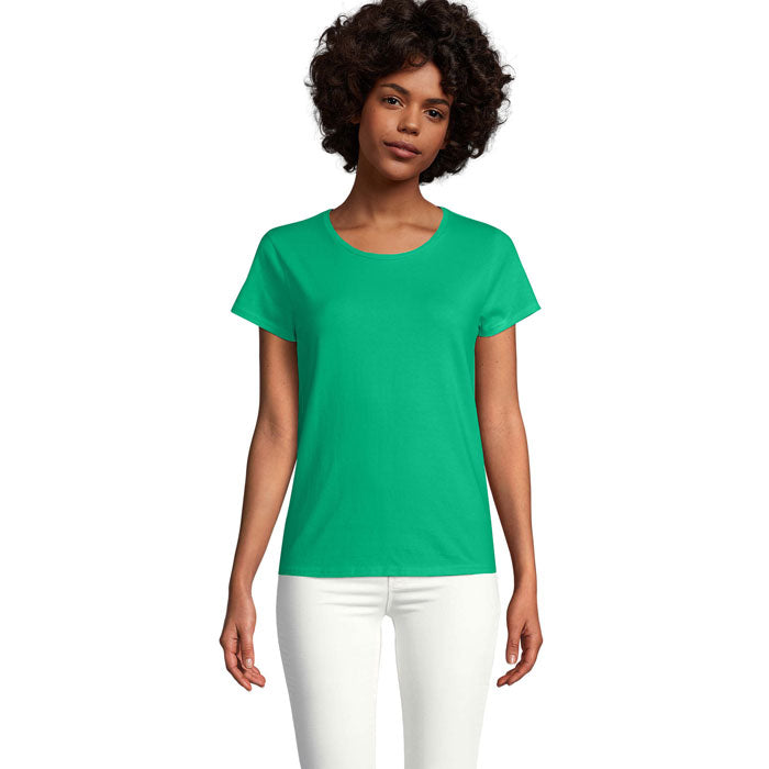 Mujer con camiseta verde ajustada de cuello redondo, fabricada en algodón orgánico, con un acabado suave.