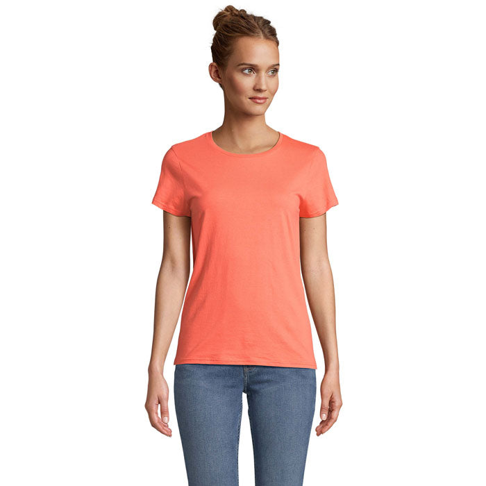 Modelo luciendo una camiseta ajustada de color coral, 100% algodón orgánico, con cuello redondo.
