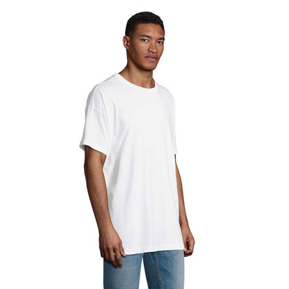 Vista lateral de hombre con camiseta blanca holgada de manga corta.